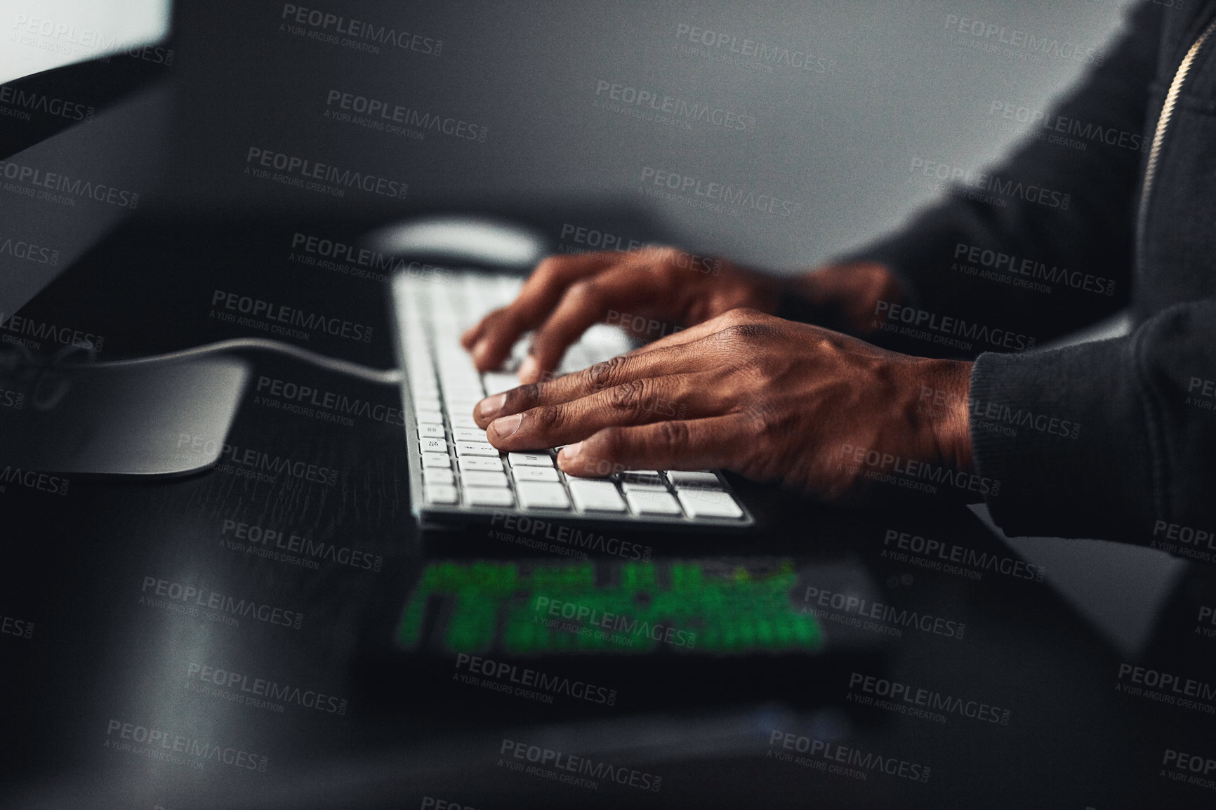 Buy stock photo Shot of an unrecognisable hacker using a computer in the dark