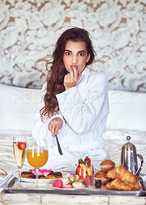 Buy stock photo Shot of an attractive young woman enjoying a luxurious breakfast in her room