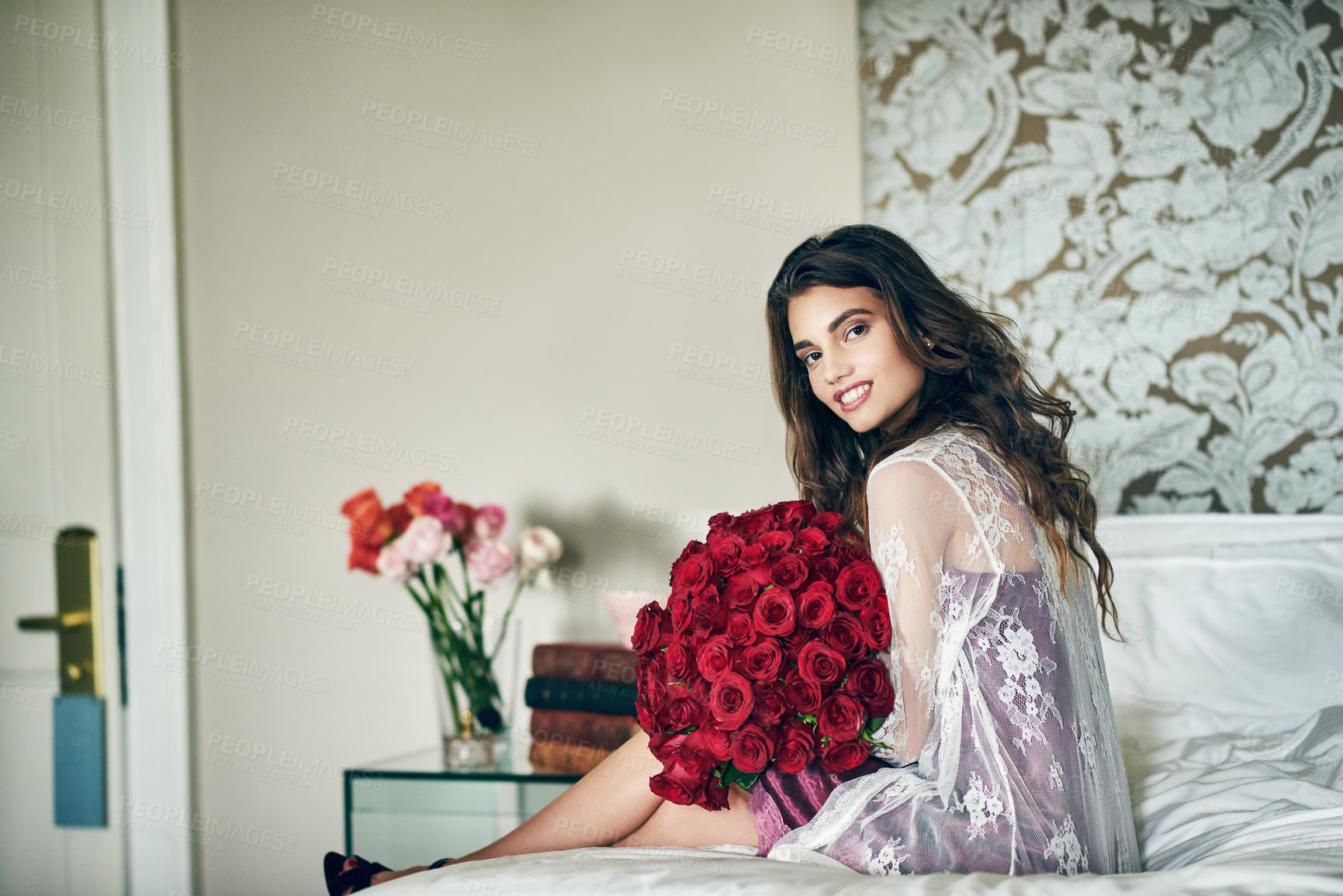 Buy stock photo Woman, bed and lingerie with bouquet of red roses as gift or present for valentines day in France. Portrait, female person and sexy or happy with flowers on lace gown with confidence at home