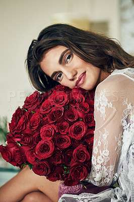 Buy stock photo Portrait of a beautiful young woman holding and resting with her face on a bouquet of roses that she bought