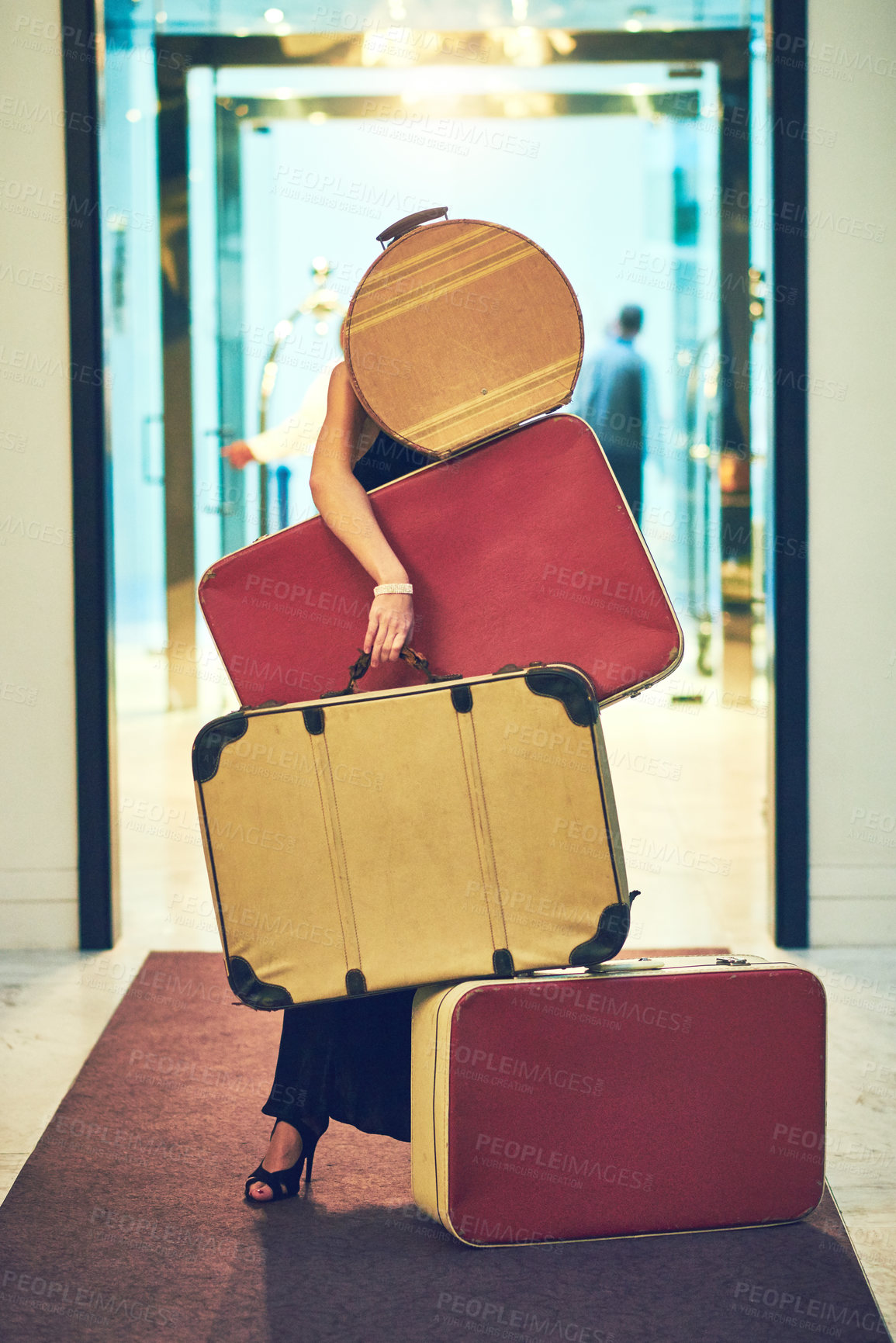 Buy stock photo Shot of an unrecognizable young woman carrying a whole bunch of luggage while trying to walk down the lobby of a hotel