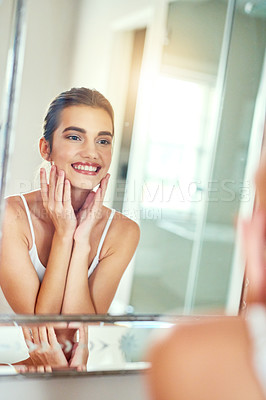 Buy stock photo Shot of an attractive young woman inspecting her skin in the mirror