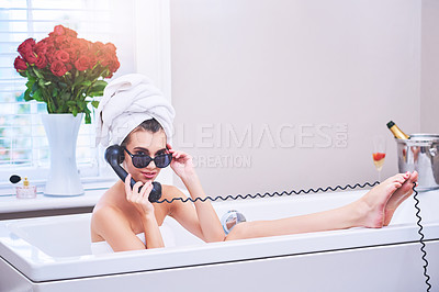 Buy stock photo Portrait of an attractive young woman talking on a telephone while sitting in a bathtub
