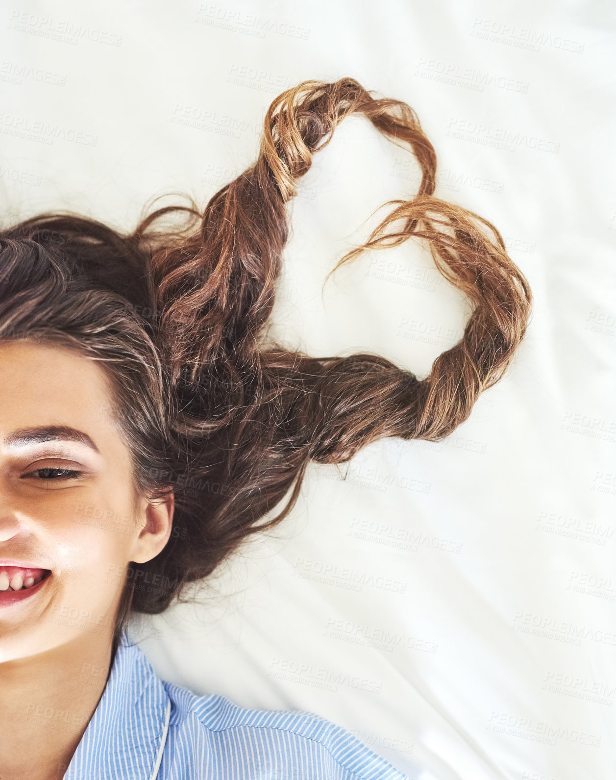 Buy stock photo Hair, half face or girl in bedroom to relax for weekend break, peace or wellness in home. Heart shape, above or happy woman lying down resting in comfortable apartment, house or morning on day off