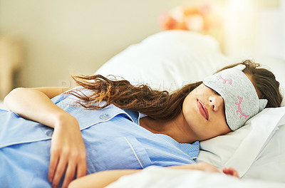 Buy stock photo Cropped shot of an attractive young woman wearing a sleep mask while lying in bed