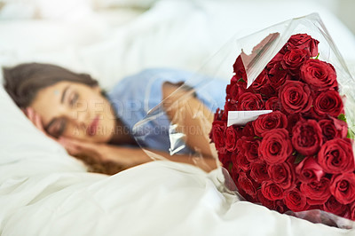 Buy stock photo Cropped shot of an attractive young woman asleep beside a bouquet of roses in her bed