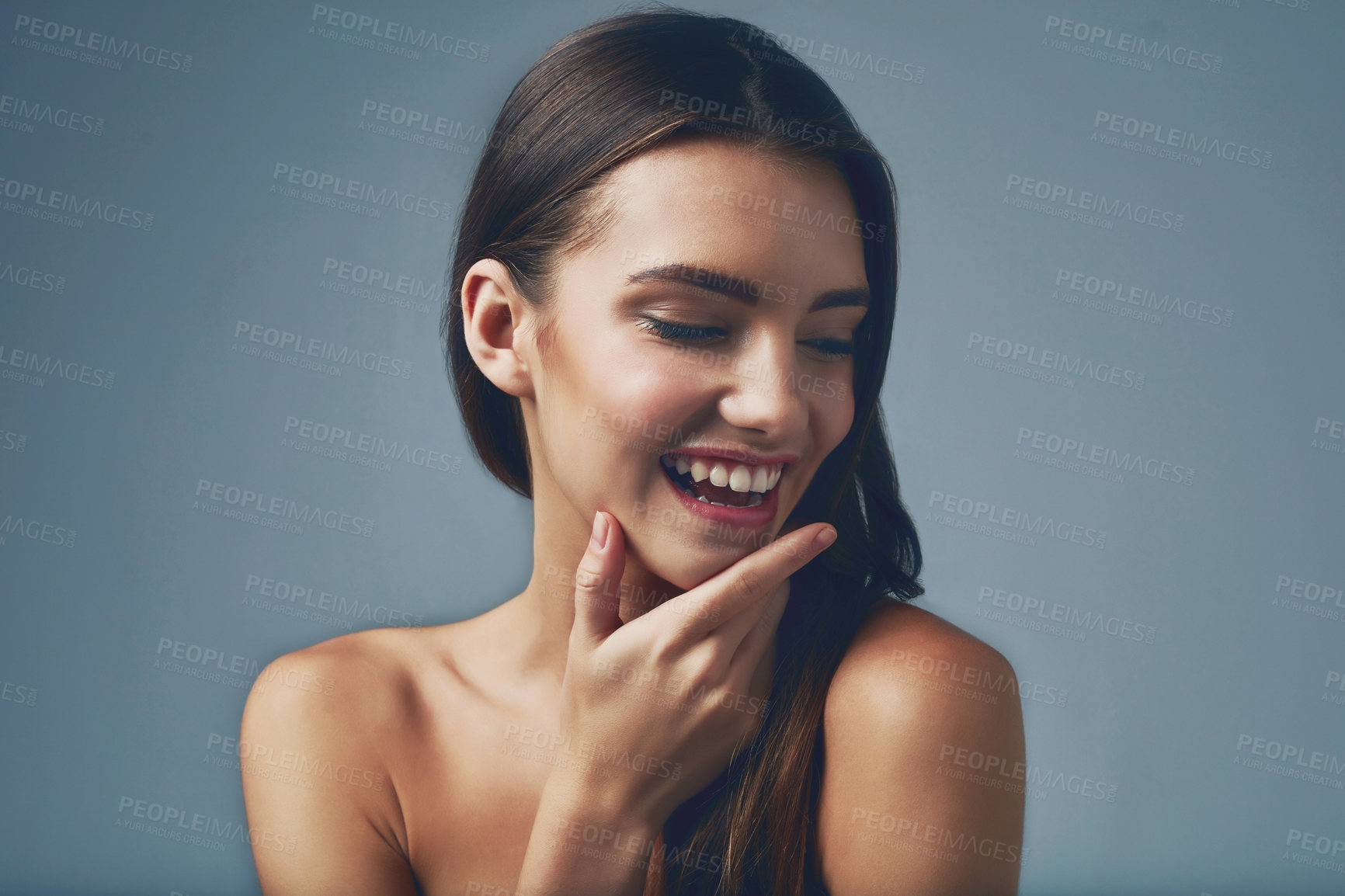 Buy stock photo Studio shot of a beautiful young woman posing against a blue background