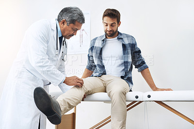 Buy stock photo Healthcare, patient with knee pain and doctor at clinic, help and wellness checkup of person at hospital. Medicine, health care expert and Indian man in doctors office consulting medical professional