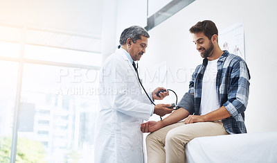 Buy stock photo Healthcare, patient and doctor with blood pressure test, help and wellness checkup of person at hospital. Medicine, health care expert and Indian man in doctors office consulting medical professional