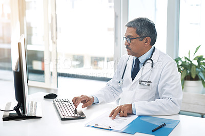 Buy stock photo Mature man, doctor and office on computer with file for patient records, report and schedule. Male person, hospital and folder or documents for database or information with telehealth or prescription