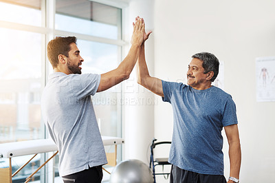 Buy stock photo Shot of two cheerful men giving each other a high five on a successful day of excise in a clinic