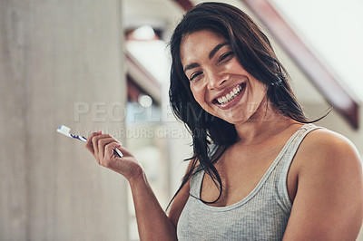 Buy stock photo Portrait of an attractive young woman brushing her teeth at home