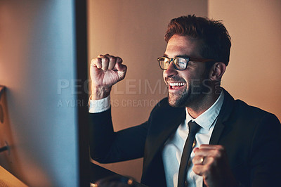 Buy stock photo Cropped shot of a handsome young businessman cheering while working late in the office