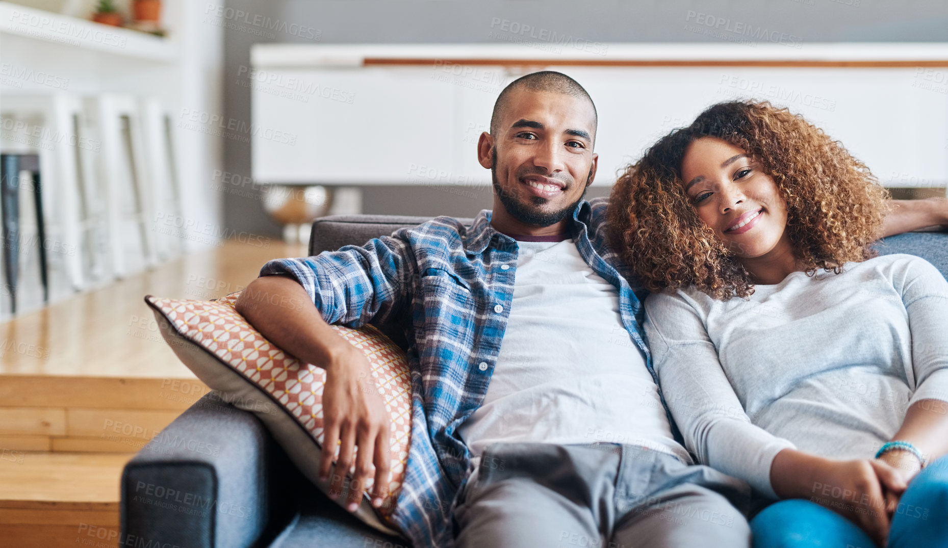 Buy stock photo Portrait of a happy young couple relaxing together on the sofa at home