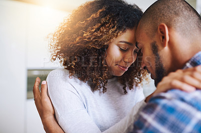 Buy stock photo Shot of a young couple embracing each other at home