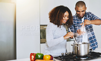 Buy stock photo Shot of a young couple cooking together at home