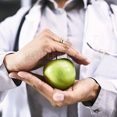 Buy stock photo Closeup shot of an unidentifiable doctor holding an apple in her hands