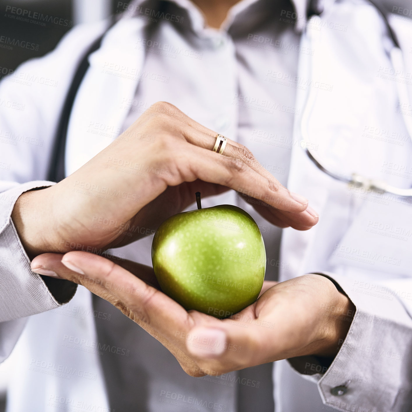 Buy stock photo Closeup shot of an unidentifiable doctor holding an apple in her hands