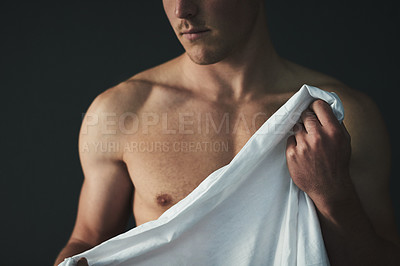 Buy stock photo Studio shot of a shirtless young man posing with a white sheet against a dark background