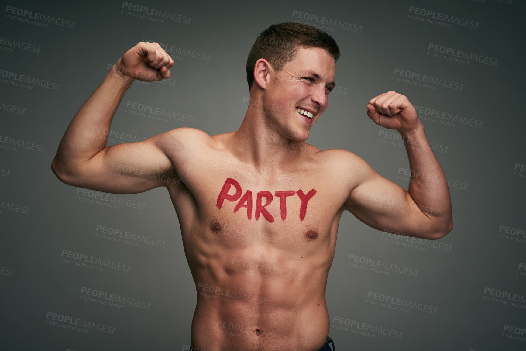 Buy stock photo Studio shot of a cheerful young shirtless man standing and flexing his muscles with the word 