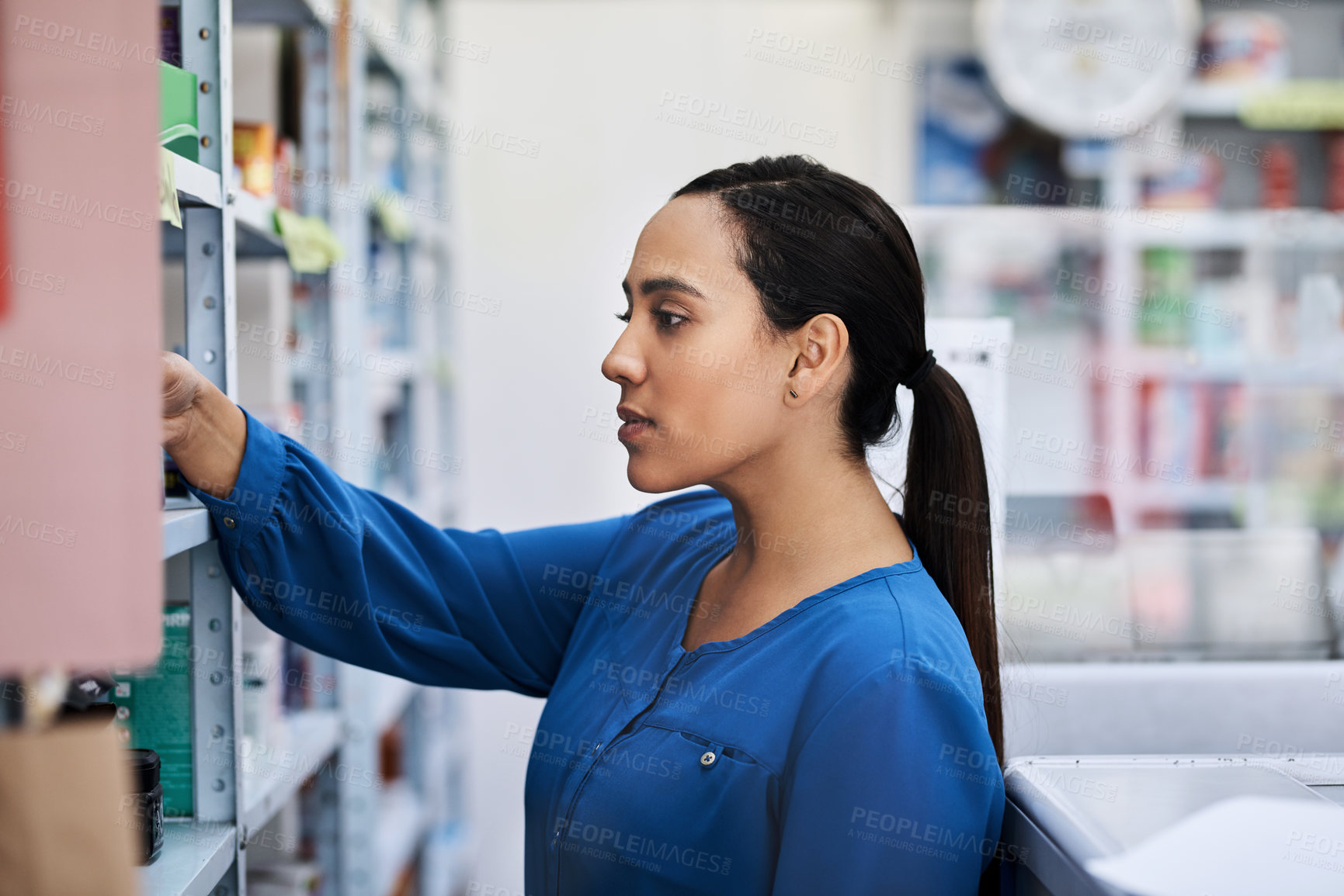 Buy stock photo Shot of a young woman shopping at a pharmacy