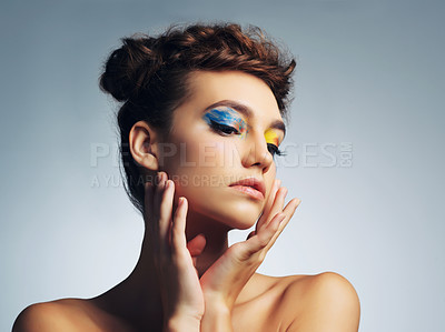 Buy stock photo Studio shot of an attractive young woman with brightly colored makeup against a gray background