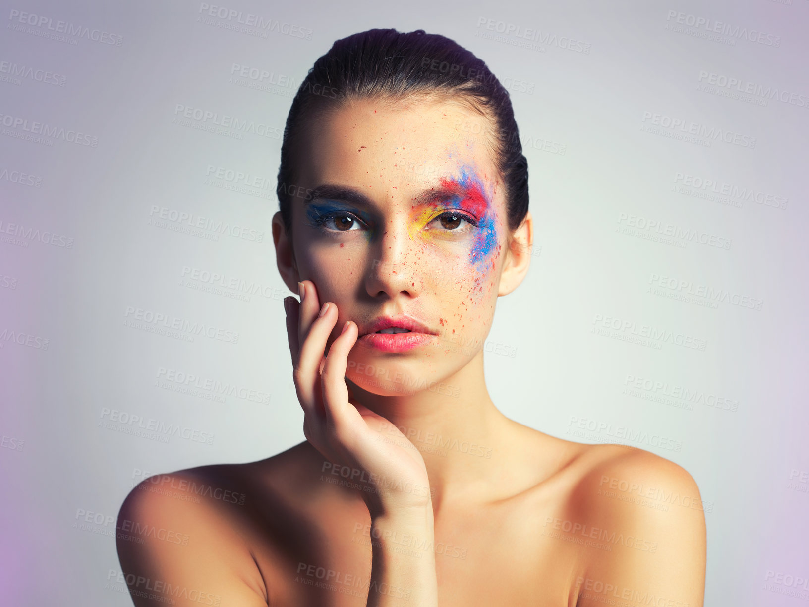 Buy stock photo Studio shot of an attractive young woman posing with her face brightly painted