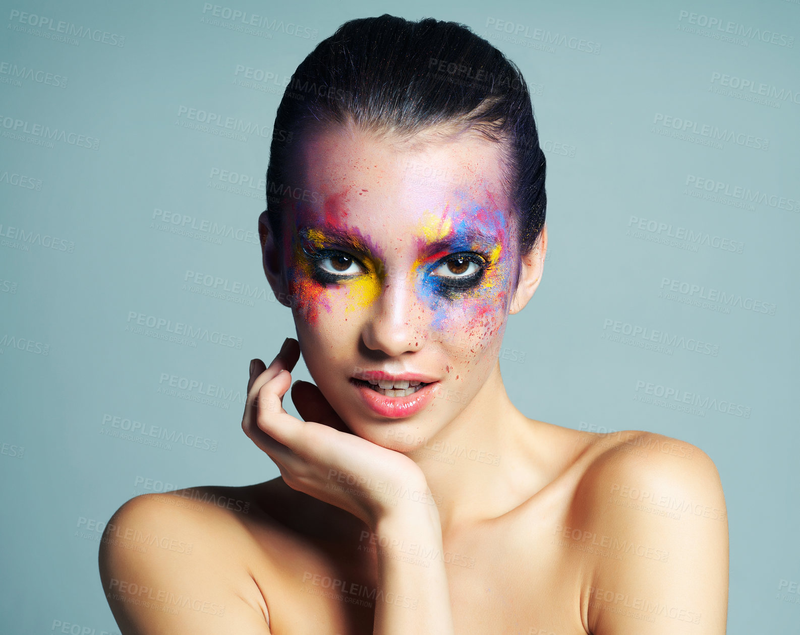 Buy stock photo Studio shot of an attractive young woman with brightly colored makeup against a blue background