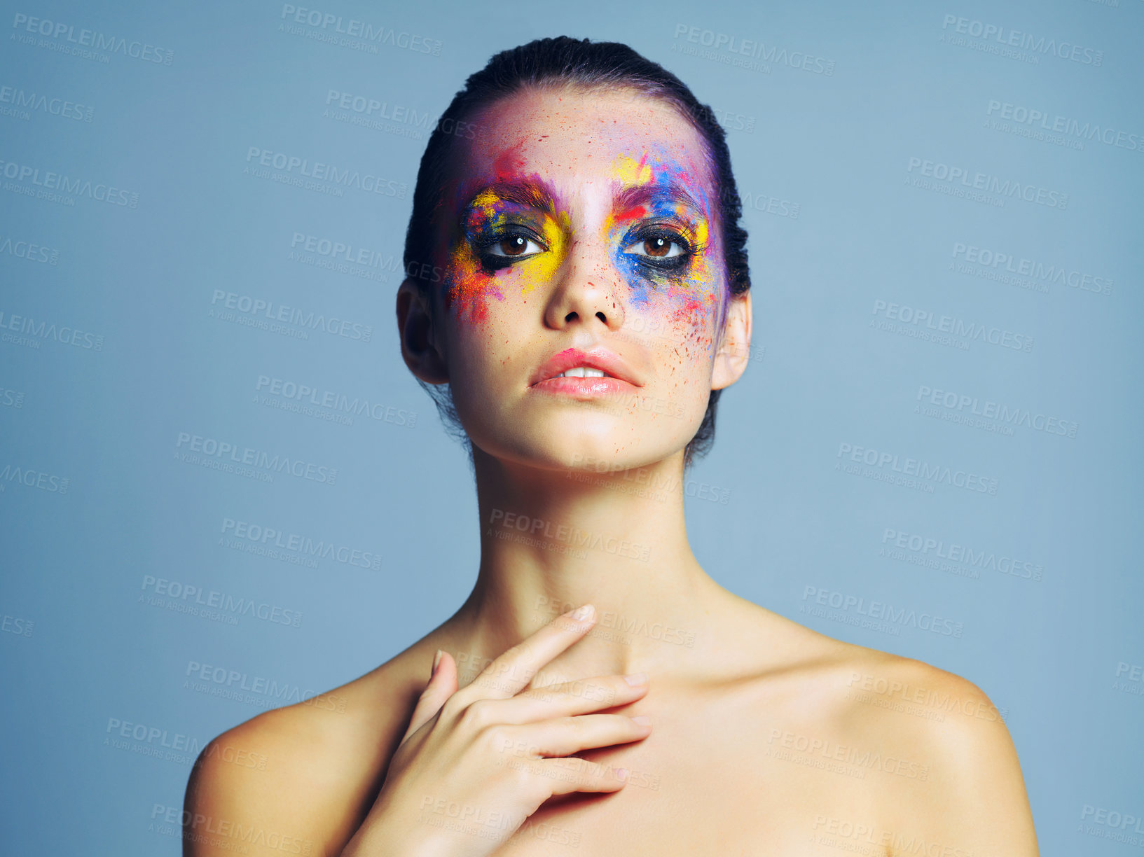 Buy stock photo Studio shot of an attractive young woman with brightly colored makeup against a blue background
