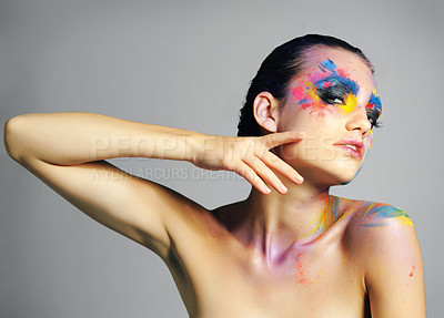 Buy stock photo Studio shot of an attractive young woman with brightly colored makeup against a gray background