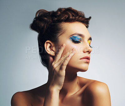 Buy stock photo Studio shot of an attractive young woman with brightly colored makeup against a gray background