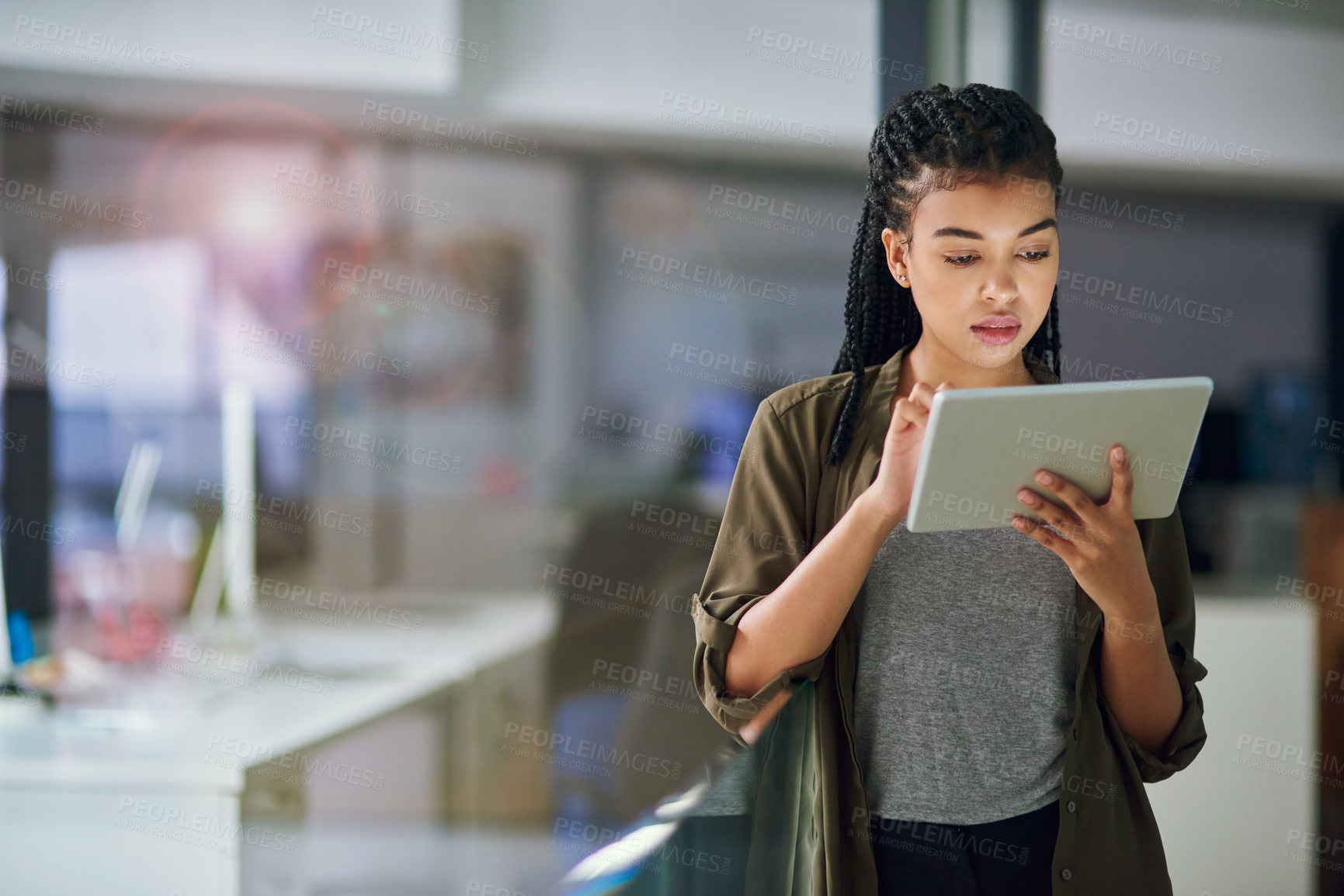 Buy stock photo Shot of a young businesswoman using a tablet at the office