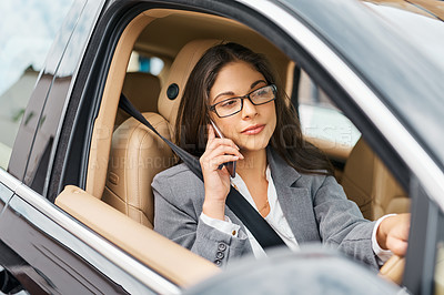 Buy stock photo Shot of a businesswoman talking on her phone while driving her car