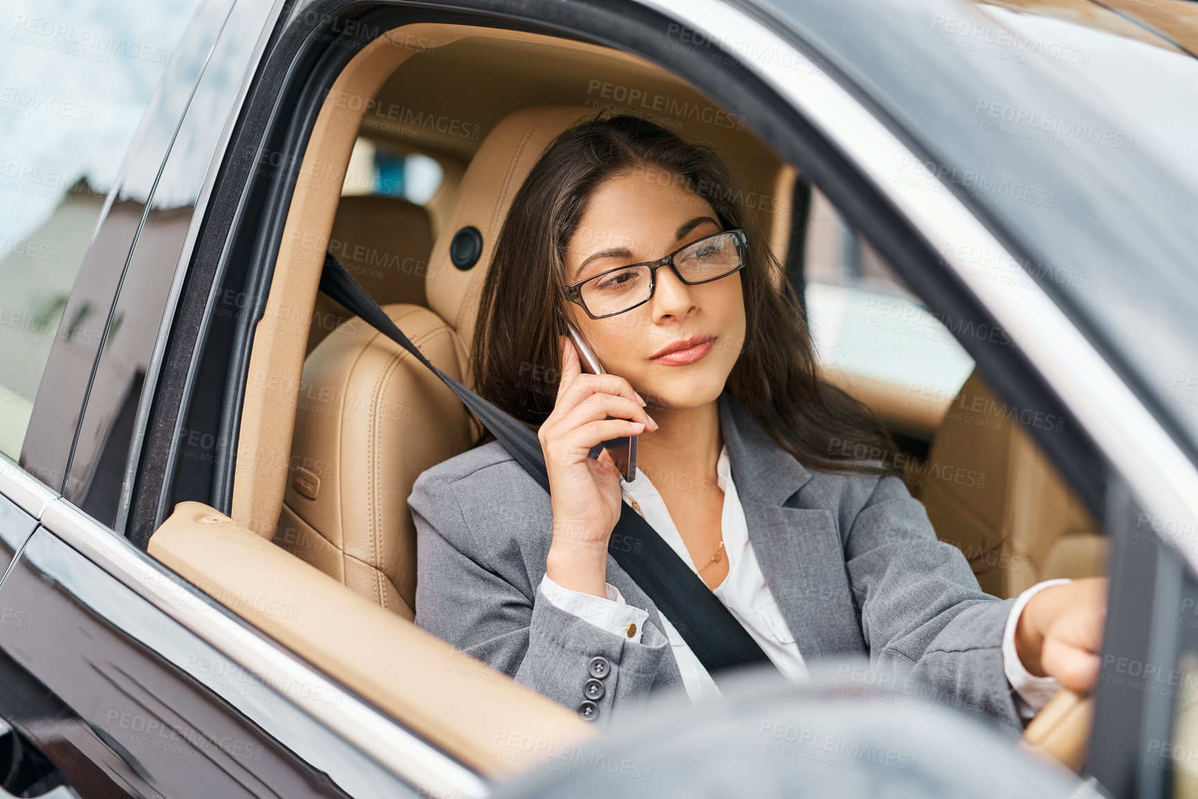 Buy stock photo Shot of a businesswoman talking on her phone while driving her car