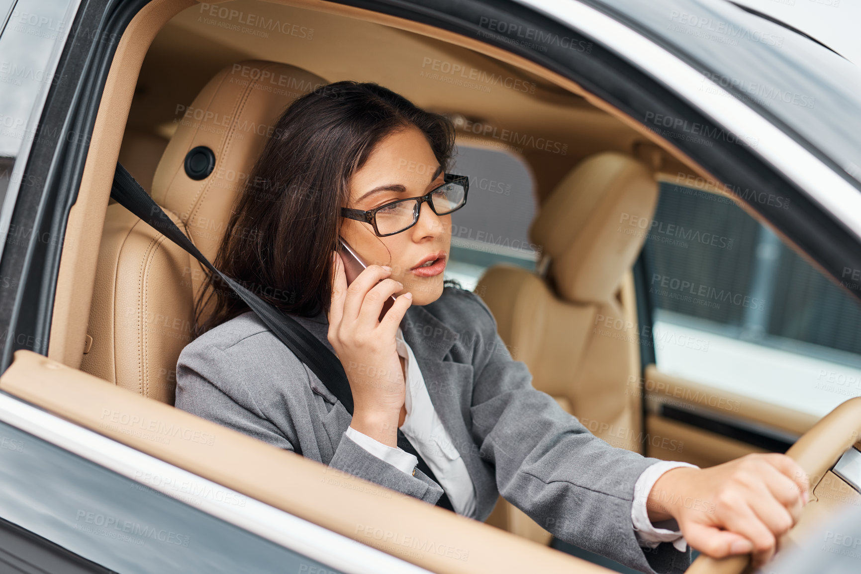 Buy stock photo Shot of a businesswoman talking on her phone while driving her car