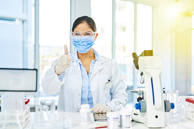 Buy stock photo Portrait of a young scientist showing thumbs up while working in a lab