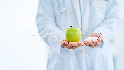 Buy stock photo Closeup shot of an unidentifiable doctor holding an apple and a variety of pills in her hands