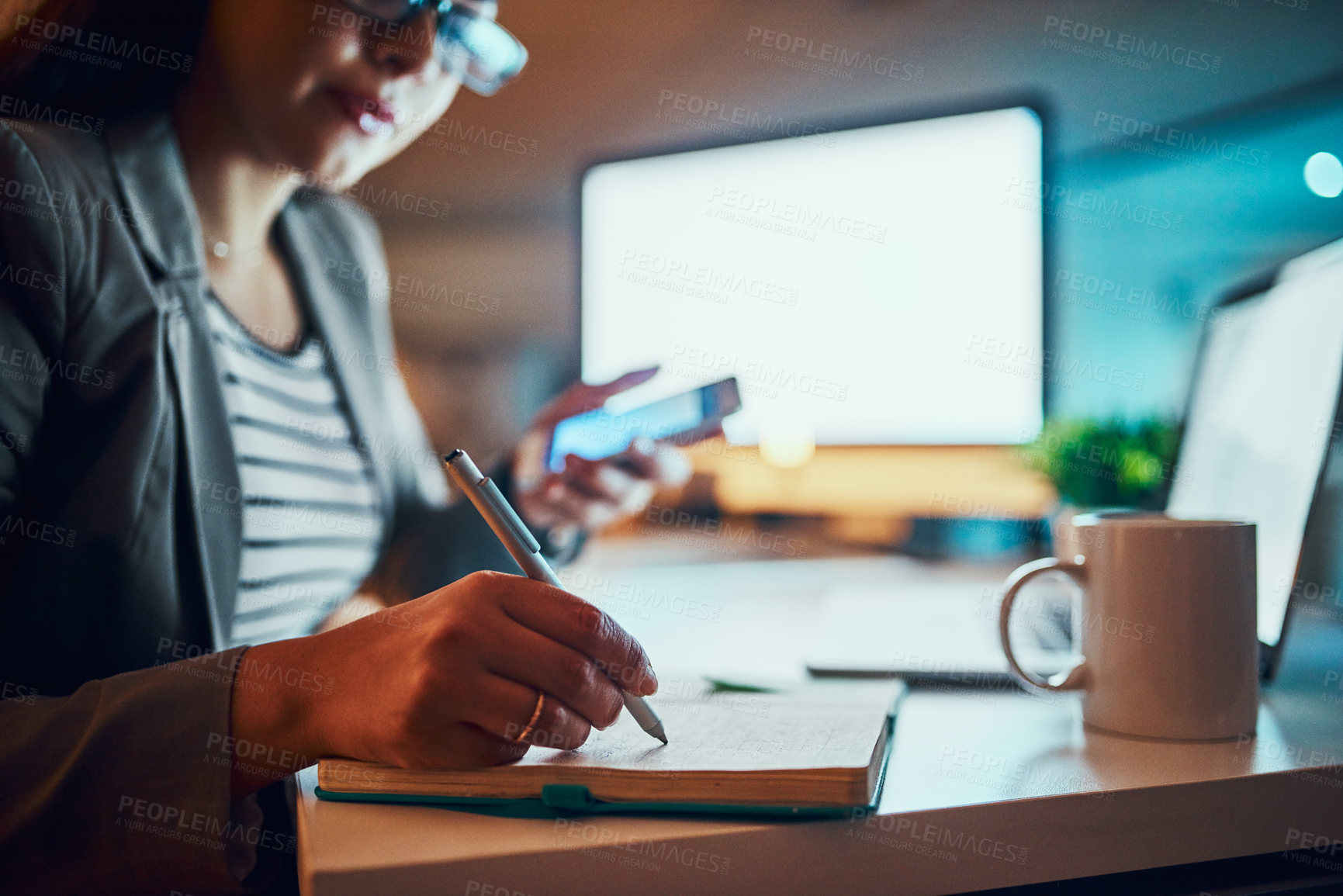 Buy stock photo Business, woman and writing in notebook in office at night for planning schedule, project deadline or calendar. Professional, employee or journal for agenda, notes or overtime at desk with smartphone