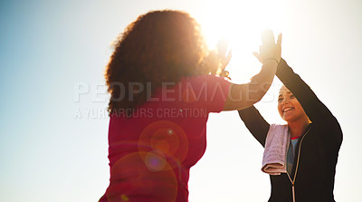 Buy stock photo Low angle shot of two cheerful young friends exchanging high fives outside during the day