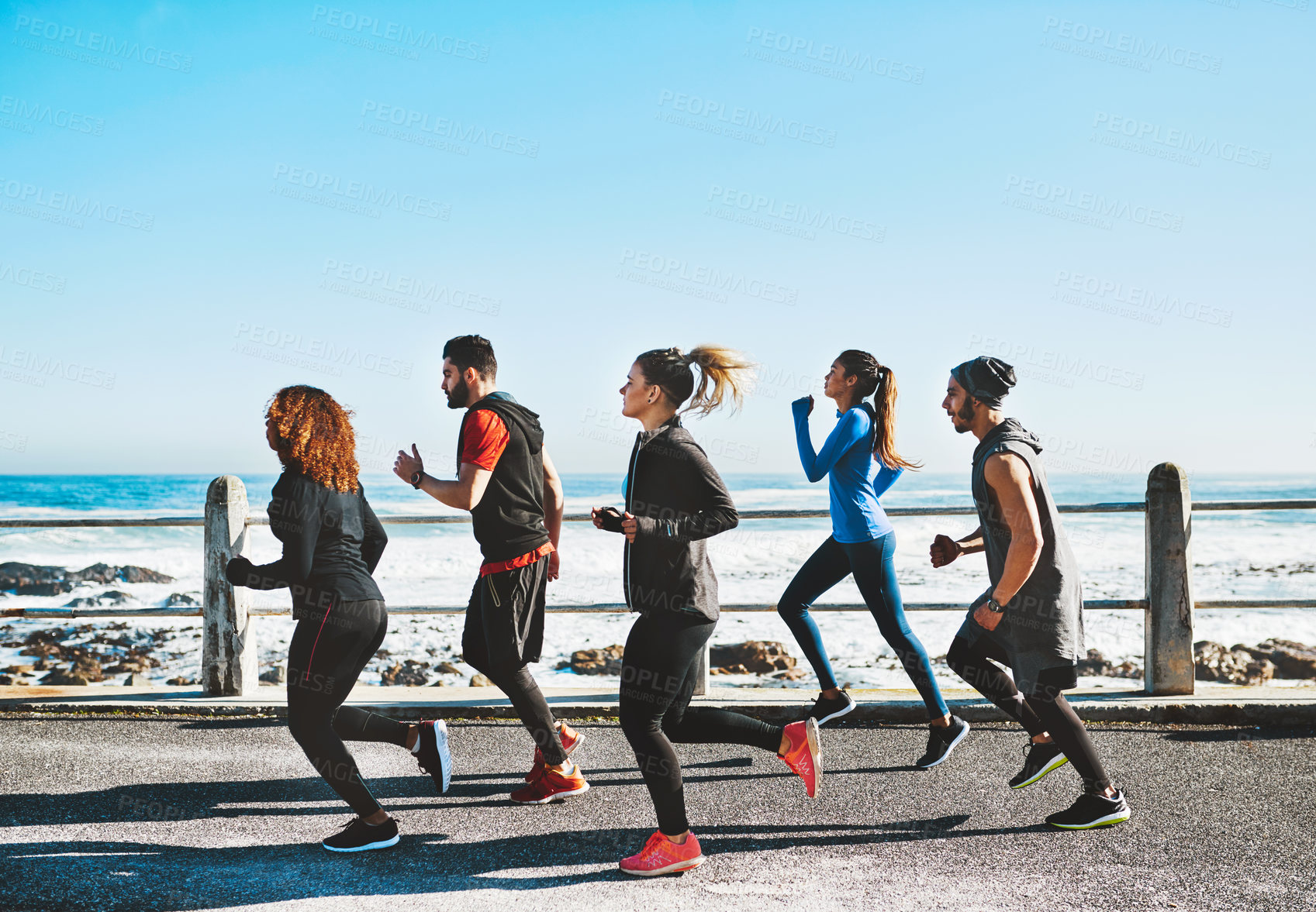 Buy stock photo Fitness, health and people running by beach for race, marathon or workout training together. Sports, activity and group of athletes with cardio exercise for wellness outdoor by ocean in morning.