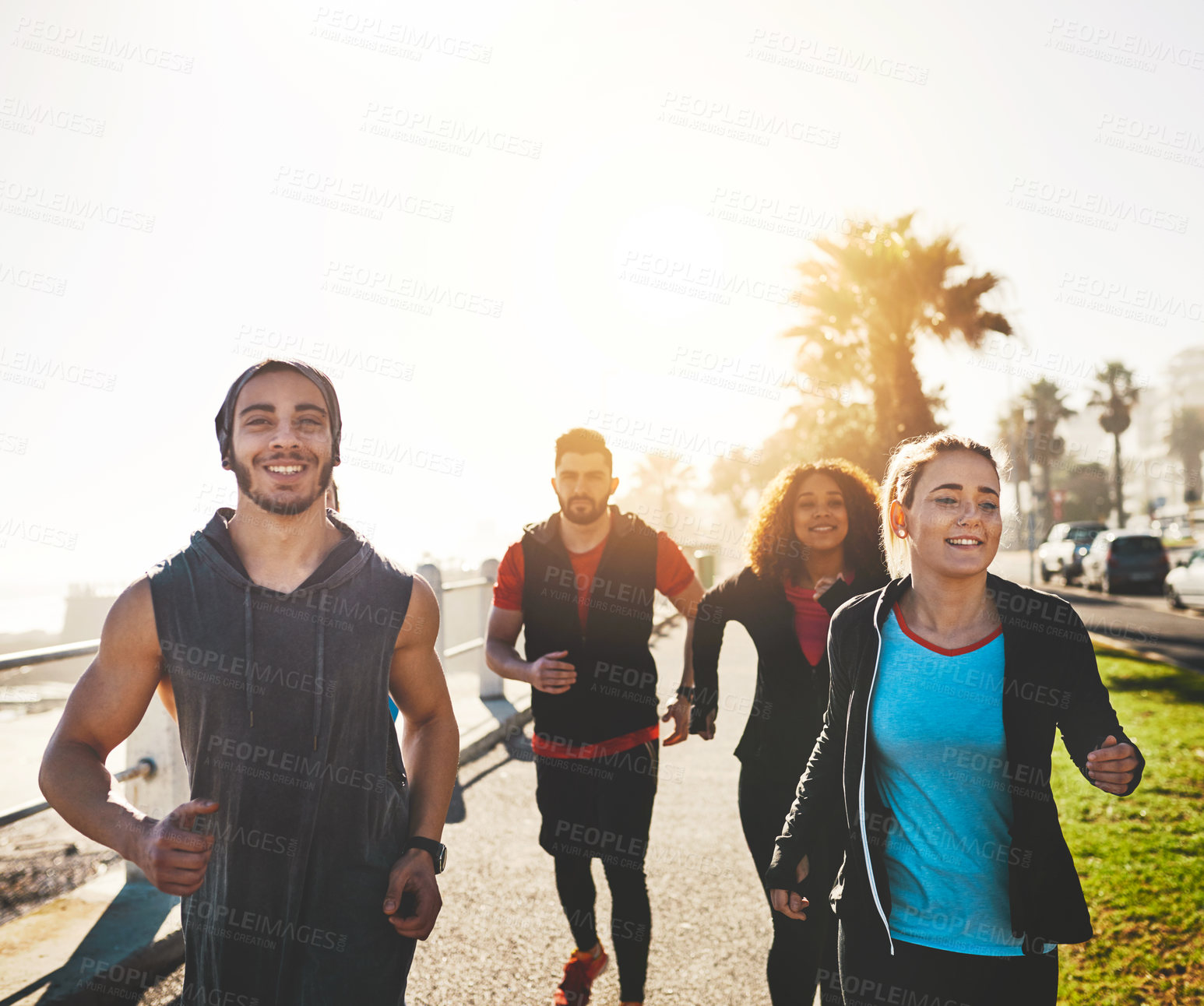 Buy stock photo Shot of a fitness group out running on the promenade