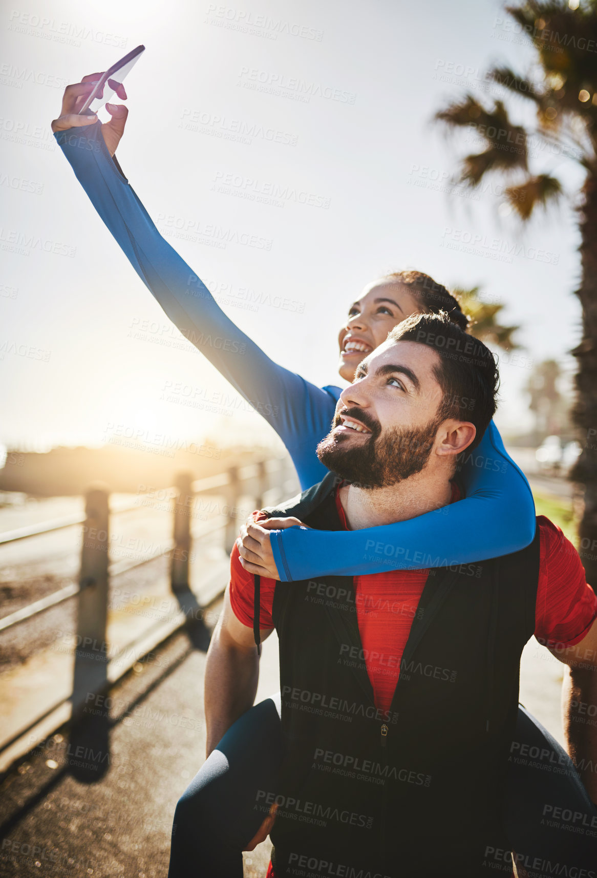Buy stock photo Shot of a woman taking a selfie while out for a run with her boyfriend