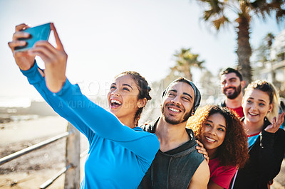 Buy stock photo Cropped shot of a fitness group taking a selfie while out for a run on the promenade