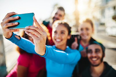 Buy stock photo Cropped shot of a fitness group taking a selfie while out for a run on the promenade