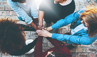 Buy stock photo High angle shot of an unrecognizable group of college friends standing outside with their hands in a huddle