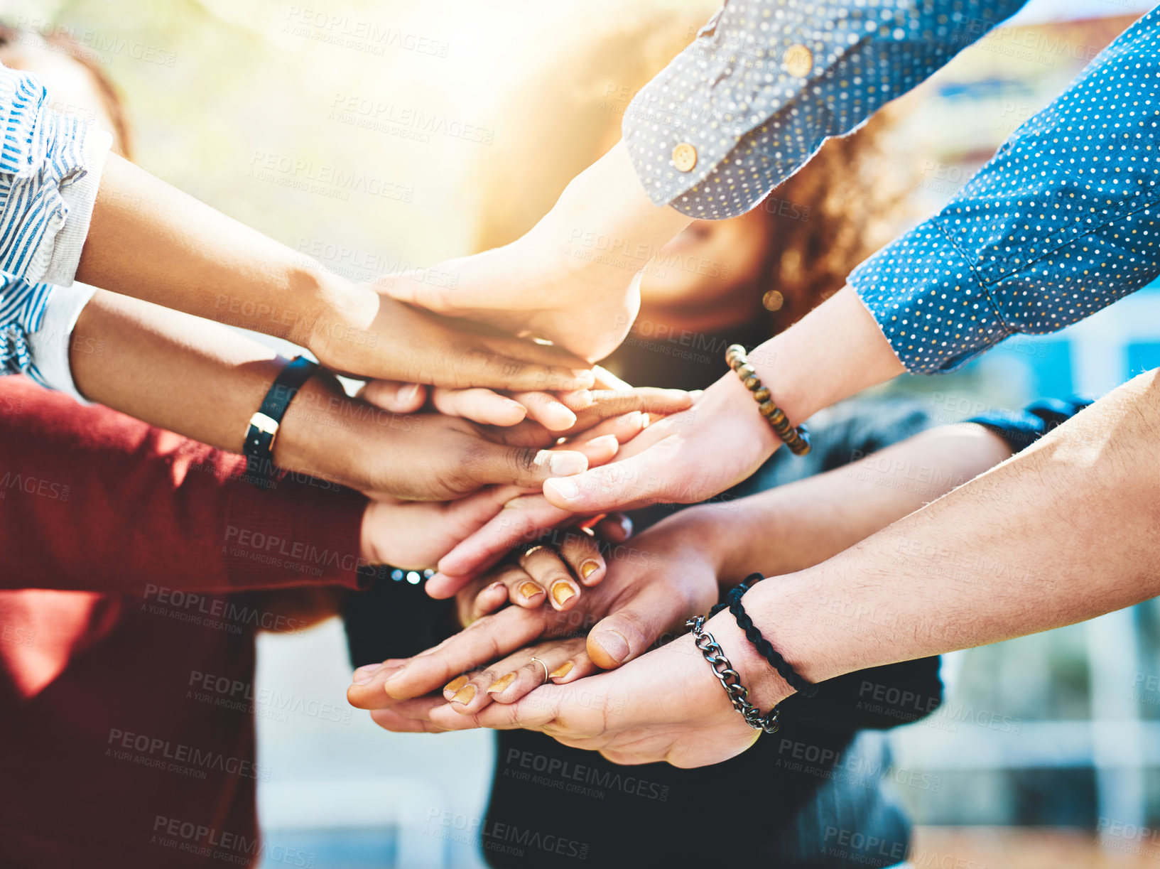 Buy stock photo Cropped shot of an unrecognizable group of college friends standing outside with their hands in a huddle