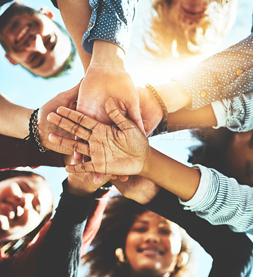 Buy stock photo High angle portrait of a diverse group of college friends standing outside with their hands in a huddle