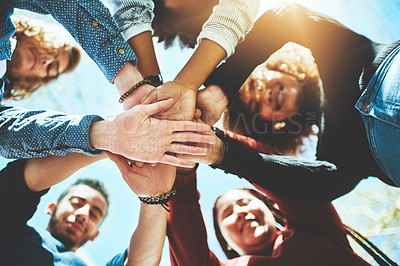 Buy stock photo High angle portrait of a diverse group of college friends standing outside with their hands in a huddle