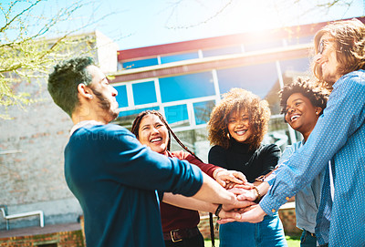 Buy stock photo Cropped shot of a diverse group of college friends standing outside with their hands in a huddle