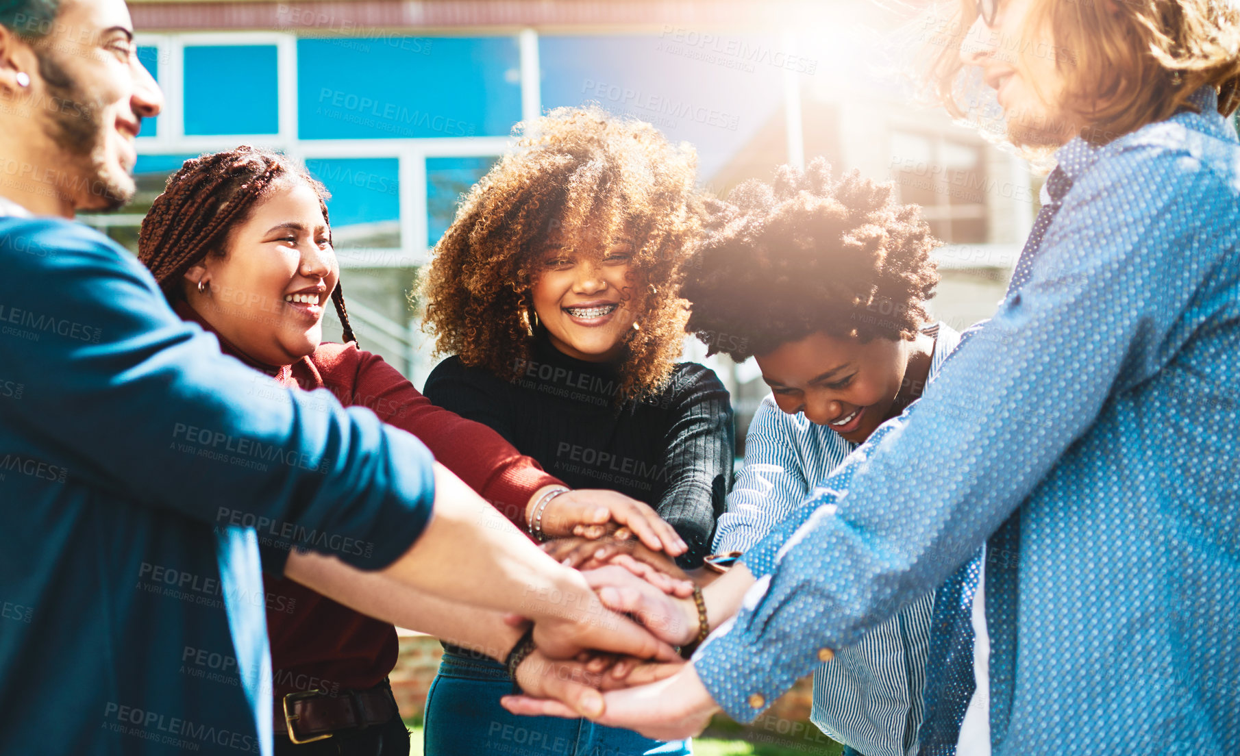 Buy stock photo Cropped shot of a diverse group of college friends standing outside with their hands in a huddle